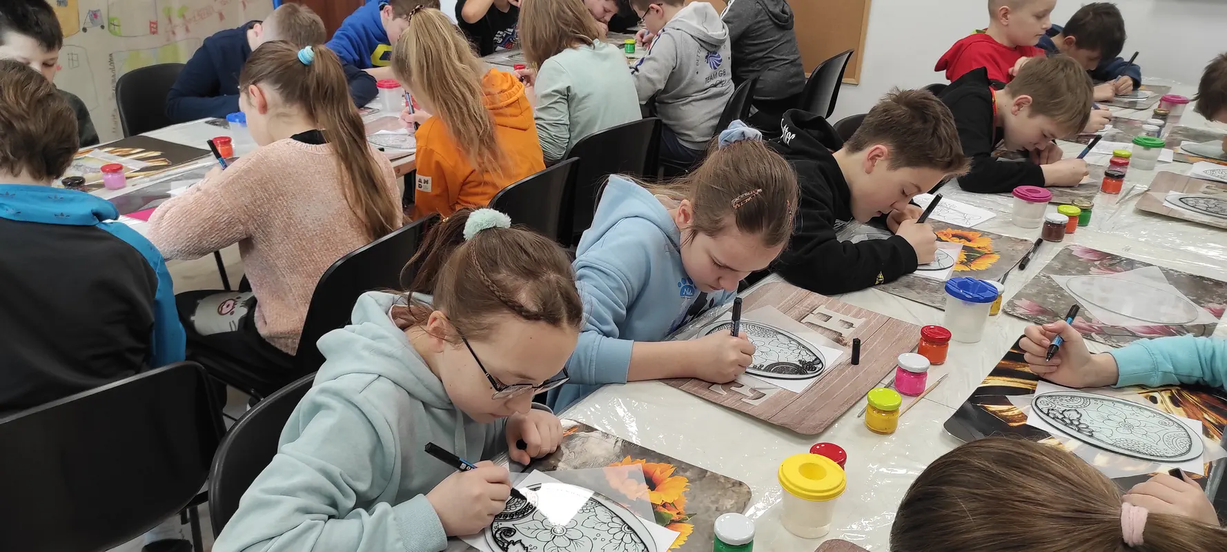 Uczniowie malują na szkle motywy wielkanocne