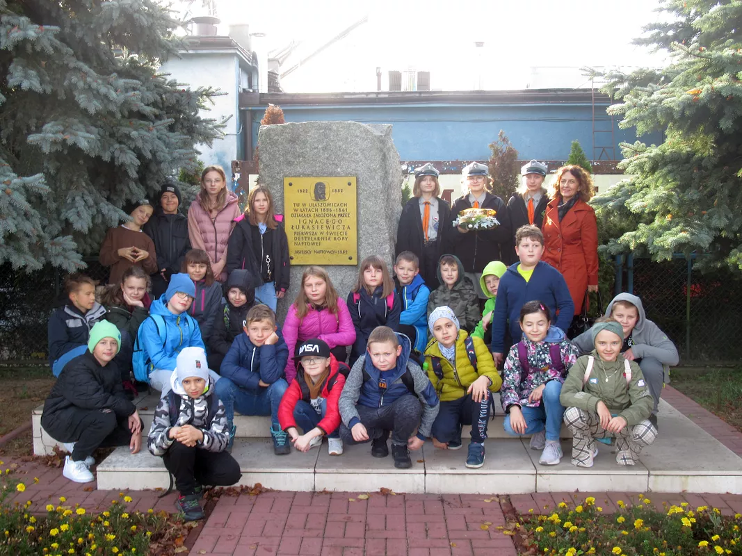Uczniowie z wychowawczynią p. Agatą Hap i z delegacją harcerek przed obeliskiem upamiętniającym pierwszą destylarnię Łukasiewicza