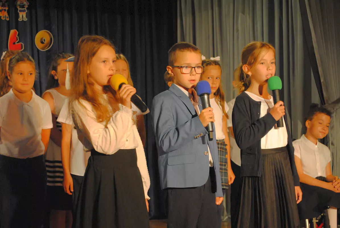 Troje uczniów śpiewa piosenkę „Zbyt krótkie wakacje”