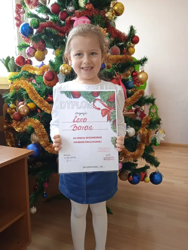 Lena Baran, z grupy Tygryski, z dyplomem za udział w konkursie Piosenki Świątecznej