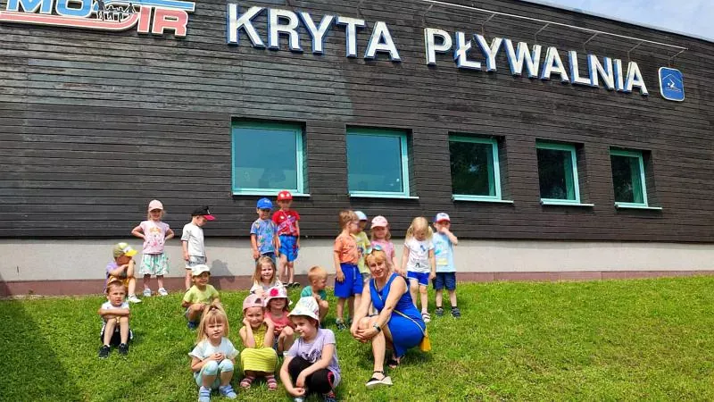 Przedszkolaki na tle obiektu MOSiR - Krytej Pływalni