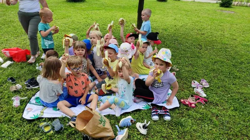 Dzieci podczas pikniku spożywają zdrową przekąskę