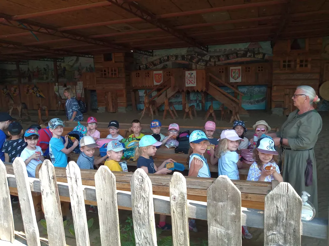 Dzieci siedzące przy drewnianym stole i zajadające się słodkościami