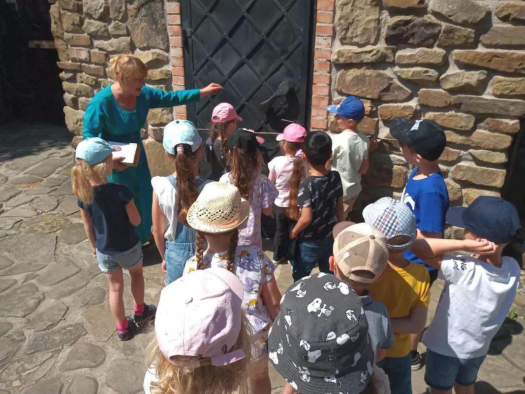 Dzieci wykonują jedno z zadań, by odszukać skarb znajdujący się na zamku. Odmierzają szerokość wieży patykami, które stanowią dawną długość łokcia