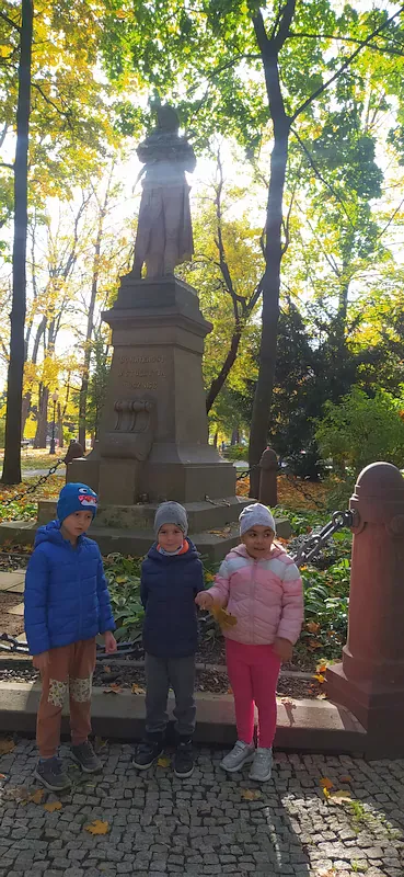 Dzieci: Eryk, Ksawery, Luiza stoją pod pomnikiem Tadeusza Kościuszki