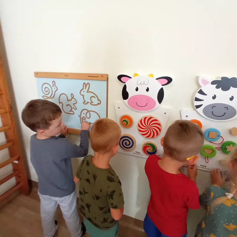 Dzieci podczas zabaw manipulacyjnych przy ściance sensoryczne w budynku B
