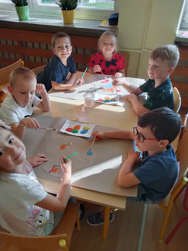 Przedszkolaki przy stoliku podczas malowania.