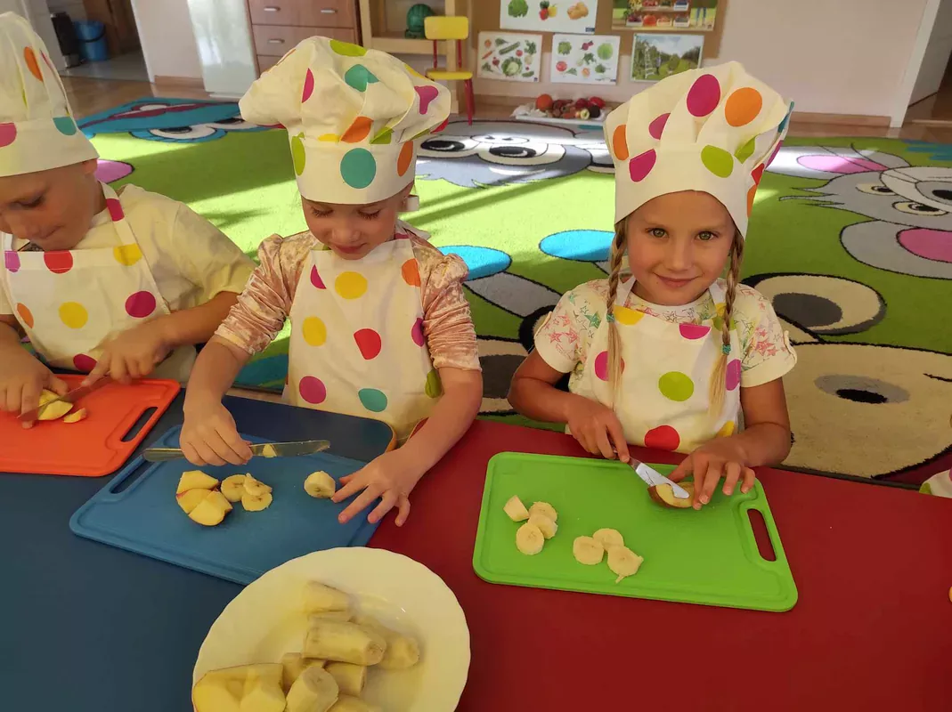 Dzieci kroja owoce