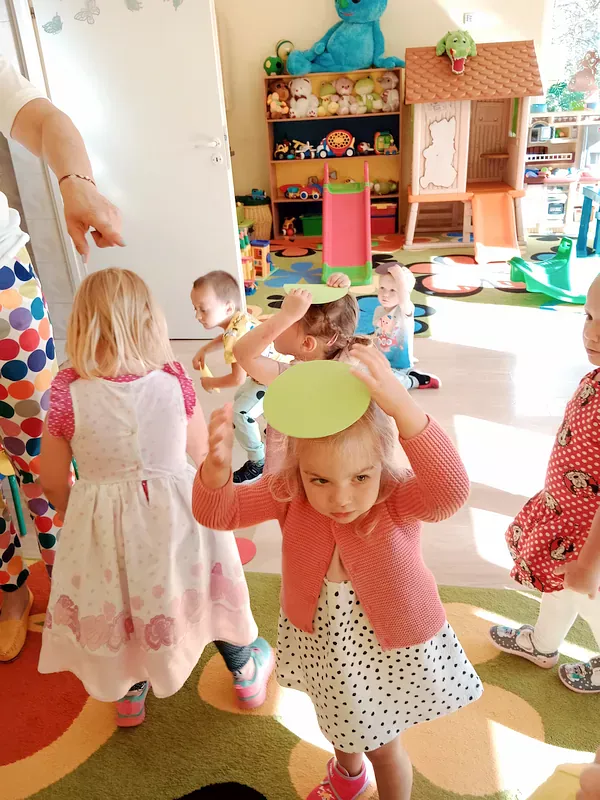 Zabawy dzieci z kolorowymi kropeczkami – na polecenie nauczyciela kładą na głowie