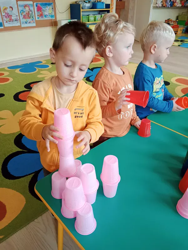 Dzieci układają wieże z kolorowych kubeczków