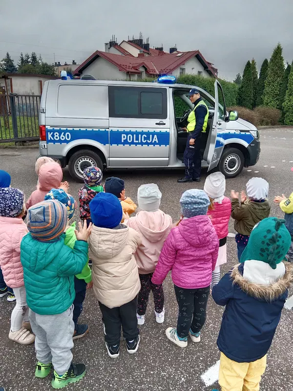 Dzieci słuchają sygnałów dźwiękowych samochodu policyjnego