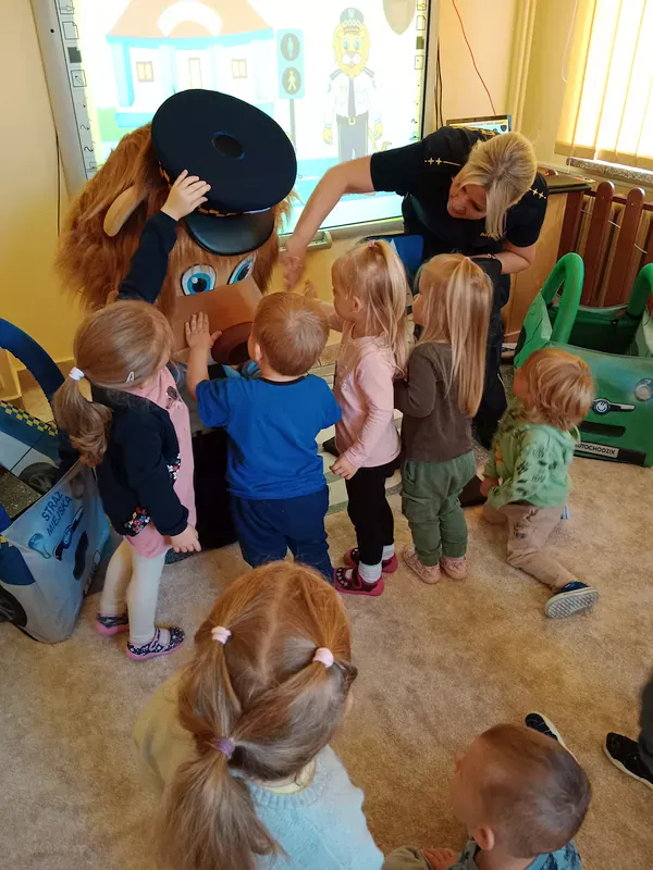 Dzieci głaskają maskotkę lwa