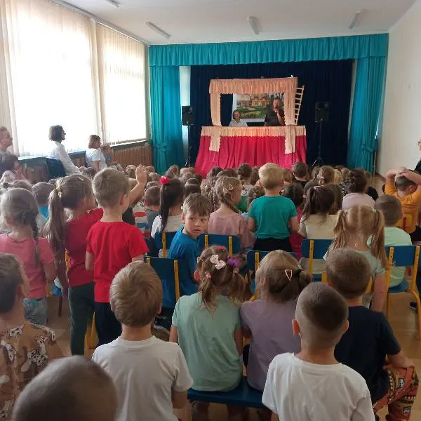 Dzieci w małej auli oglądają przedstawienie